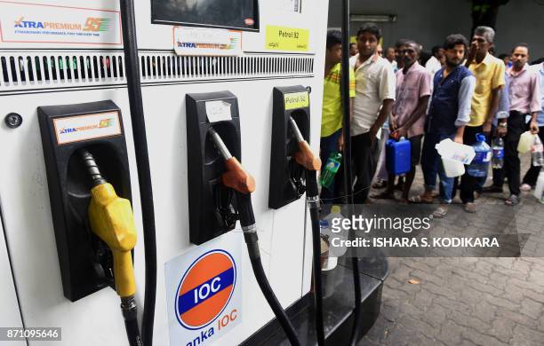 Sri Lankan commuters wait in a queue at a fuel station in Colombo on November 7, 2017. A Sri Lankan minister was forced on November 6 to apologise...