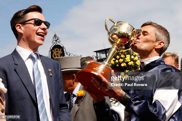 Trainer Joseph O'Brien looks on as jockey Corey Brown kisses the Melbourne Cup after winning race 7, the Emirates Melbourne Cup on Rekindling on...