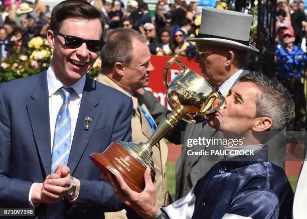 Corey Brown jockey on Rekindling kisses the cup as trainer Joseph OBrien looks on after they won the 157th Melbourne Cup at Flemington Racecourse in...