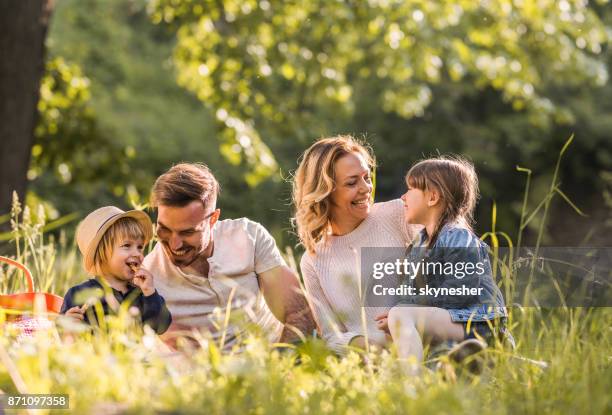 jeune heureuse famille jouissant sur pique-nique au cours de la journée de printemps dans la forêt. - pique nique photos et images de collection