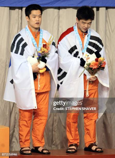 Korea's Cho Kwan-Hoon and Kwon Kyung-Min celebrate after receiving the silver in the men's 10m Synchronized Diving event 08 October 2002 at the 14th...