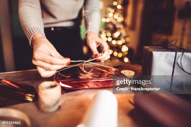 woman making the package for the christmas gift - gift giving holiday stock pictures, royalty-free photos & images