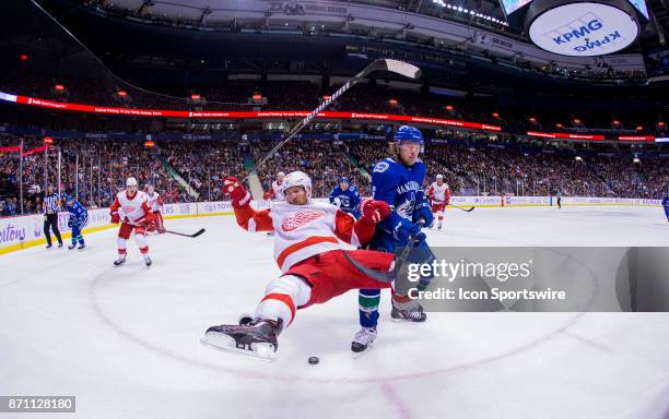Vancouver Canucks Right Wing Brock Boeser trips up Detroit Red Wings Winger Darren Helm in a NHL hockey game on November 06 at Rogers Arena in...