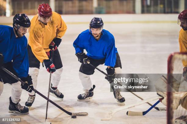 group of determined ice hockey players tackling during a match at rink. - defenseman ice hockey stock pictures, royalty-free photos & images