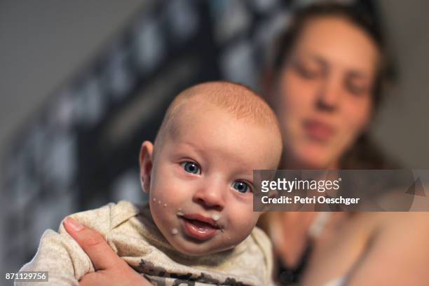 a young mother burping her baby boy after breastfeeding. - brustwarze stock-fotos und bilder