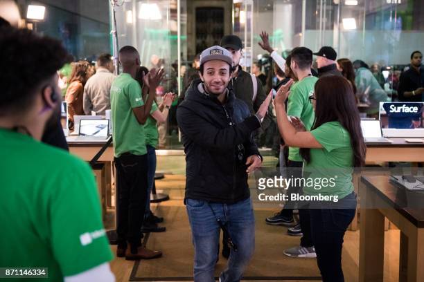 Employees greet customers as they enter the store to pre-pay for an Xbox One X game console ahead of it's midnight release during the Microsoft Corp....