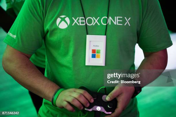 The Microsoft Corp. Flagship store employee plays on an Xbox Developer Kit version of the Xbox One X game console during the global launch event in...