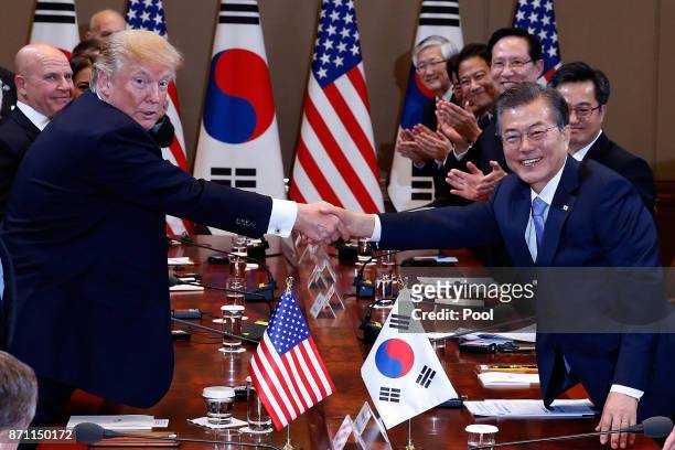 South Korean President Moon Jae-In shakes hands with U.S. President Donald Trump during their summit at the presidential Blue House on November 7,...