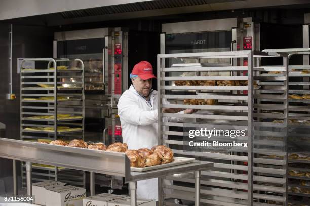 An employee places freshly roasted rotisserie chicken on to a rack inside a Costco Wholesale Corp. Store in Villebon-sur-Yvette, France, on Friday,...