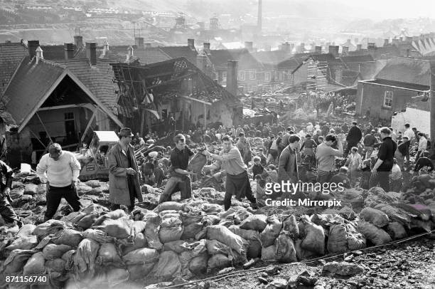 Rescue workers bagging and moving some of the coal spoil following the catastrophic collapse of a colliery spoil tip in the Welsh village of Aberfan,...