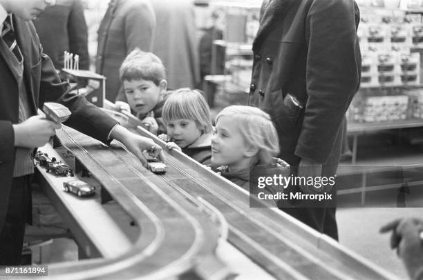 Group of children look on longingly at the latest Scalextric slot car racing set in the toy department of Heelas department store in Reading, all...