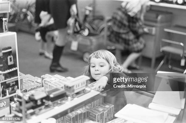 Small girl looks on longingly at the latest Lego set in the toy department of Heelas department store in Reading, she hopes that Santa has one in his...