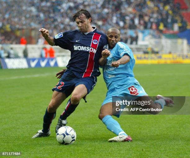 Le defenseur de l'Olympique de Maarseille, le Capverdien Manuel Dos Santos , essaie de tacler son homologue du Paris Saint-Germain, l'Espagnol...