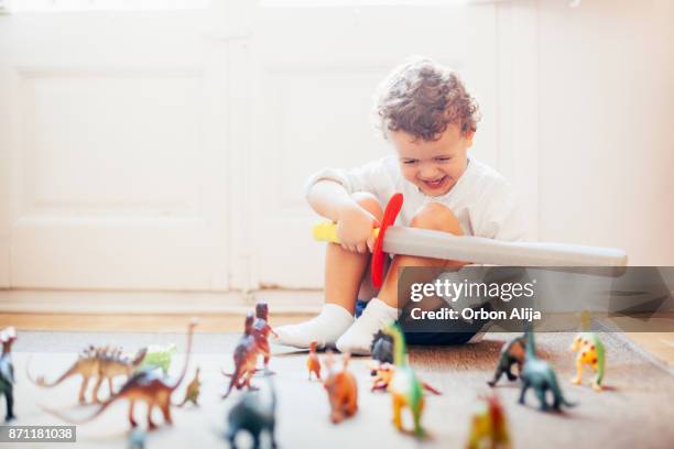 boy playing with toy dinosaurs - toy sword stock pictures, royalty-free photos & images