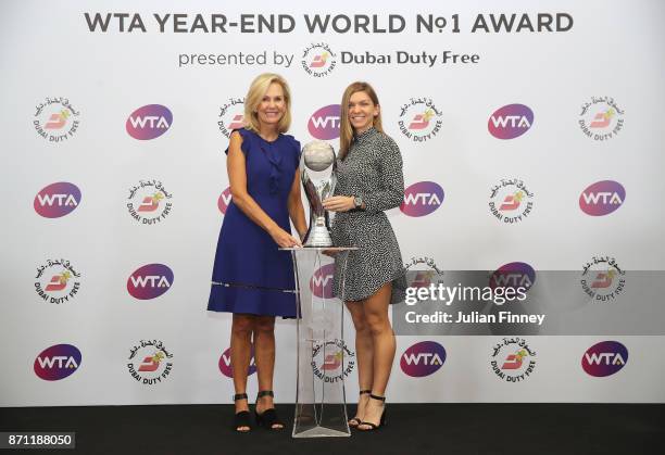 Simona Halep of Romania poses with the WTA Year-End World No.1 Award presented by Dubai Duty Free and Micky Lawler, WTA President during day 8 of the...