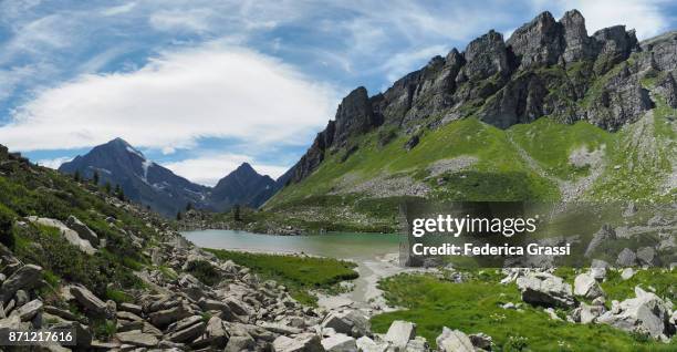 woman and child walking in the water of alpine lake lago bianco, alpe veglia natural park - veglia stockfoto's en -beelden