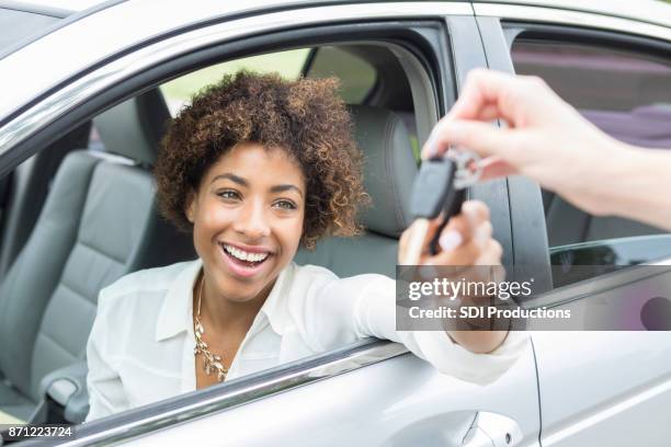 joven emocionada acepta las llaves del coche nuevo - used car fotografías e imágenes de stock