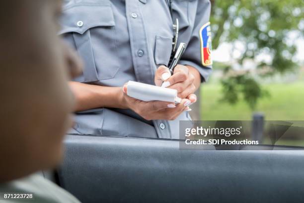 fahrer wartet als polizist beschleunigung schreibt ticket - citation stock-fotos und bilder