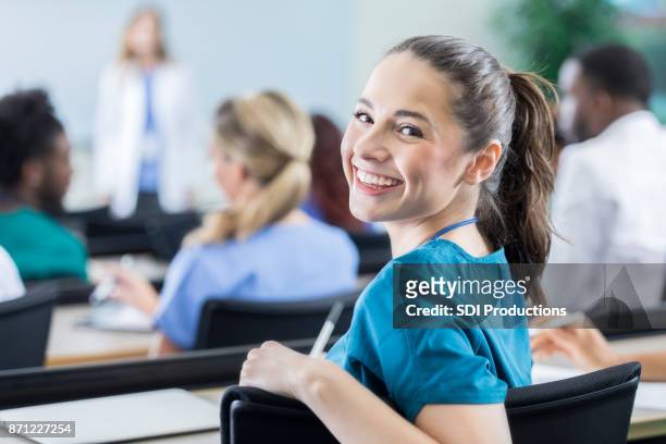 fröhliche weiblicher medizinstudent im klassenzimmer - unterrichten stock-fotos und bilder