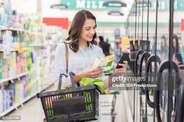 jovem mulher lê a etiqueta no produto de alimentos congelados - frozen food - fotografias e filmes do acervo