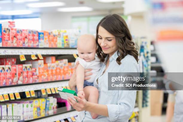 mom reads label on over the counter medication - pharmacy customer stock pictures, royalty-free photos & images