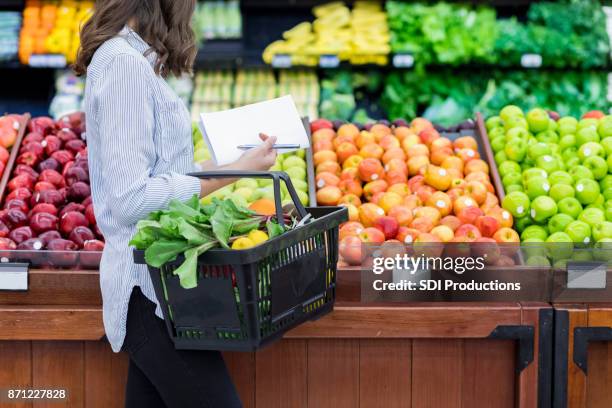 nicht erkennbare frau kauft für produzieren im supermarkt - female supermarket stock-fotos und bilder