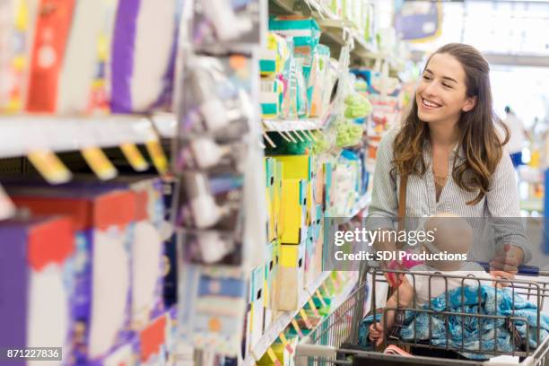 junge mutter durchsucht baby traualtar im supermarkt - adult diapers stock-fotos und bilder