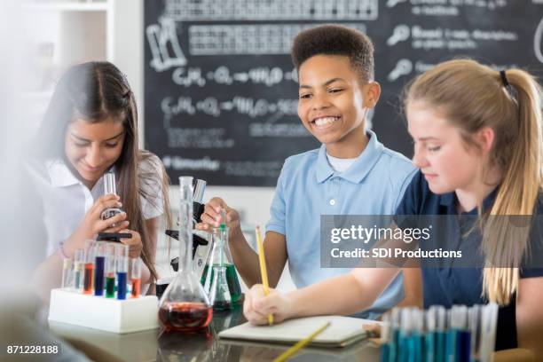 groupe de collégiens élèves travaillent sur le projet de classe - expérience scientifique scolaire photos et images de collection