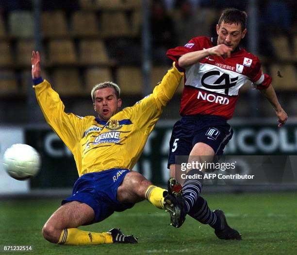 Le milieu lillois Bruno Cheyrou tente un tire au but malgré le tacle du défenseur de Geugnon Johann Bouzin, le 15 avril 2000 au stade Grimonprez...