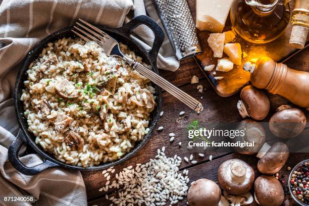 risotto funghi porcini su tavolo rustico in legno - mushroom foto e immagini stock