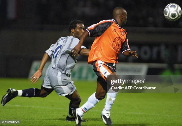 Le milieu de terrain nigérien du PSG Augustin Okocha tente de passer le milieu de terrain de Lorient Tchiressoua Guel, le 15 septembre 2001 à...