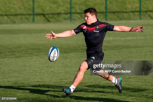 French national rugby union team scrumhalf Antoine Dupont kicks the ball as he practices during a training session in Marcoussis, near Paris, on...