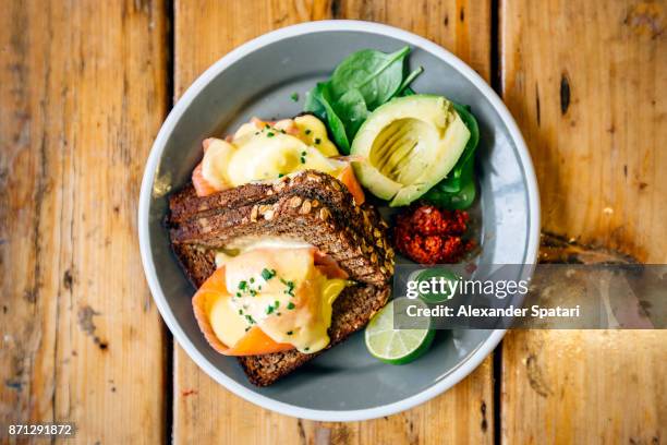 healthy breakfast with rye bread, salmon, poached egg, avocado and lime - rogge graan stockfoto's en -beelden