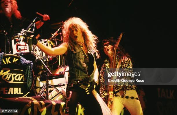 Brett Michaels , lead singer for the "big hair" metal rock band, Poison, and guitarist Bobby Dall prance on stage during a 1987 Long Beach,...