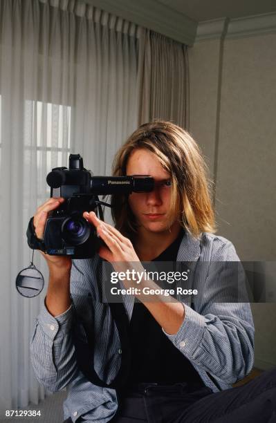 Actor River Phoenix, star of "Stand By Me," playfully poses with a video camera during a 1988 Los Angeles, California, photo portrait session....