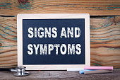 signs and symptoms. Chalkboard on a wooden background