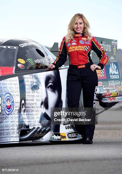 Funny Car driver Courtney Force poses with her Advance Auto Parts Chevrolet Camaro SS funny car featuring the cover of Big Machine Records recording...