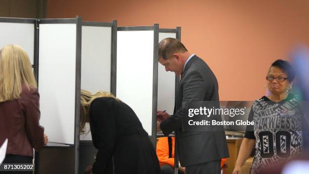 Boston Mayor Martin J. Walsh votes with his partner Lorrie Higgins, left, and her daughter Lauren Campbell, center, at the Lower Mills Branch of the...