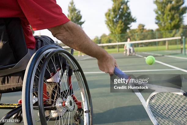 low section view of a man sitting in a wheelchair and playing tennis. - wheelchair tennis stockfoto's en -beelden