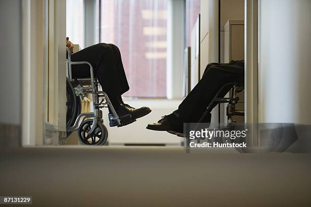 low section view of two business executives sitting in wheelchairs - lower employee engagement stock pictures, royalty-free photos & images