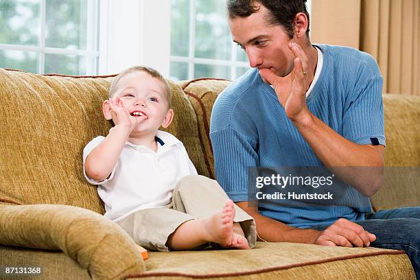 father teaching son sign language - american sign language stock pictures, royalty-free photos & images