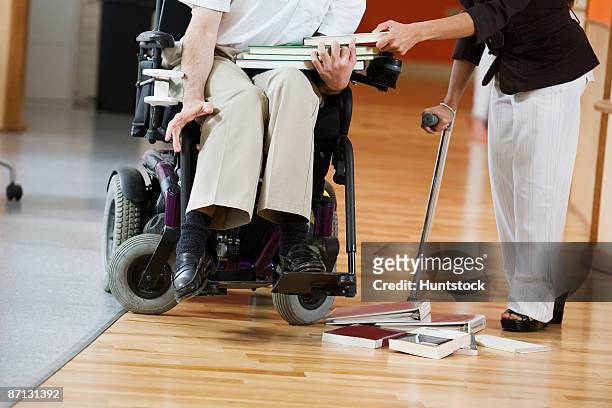 low section of a handicapped man and woman holding books - lower employee engagement stock pictures, royalty-free photos & images