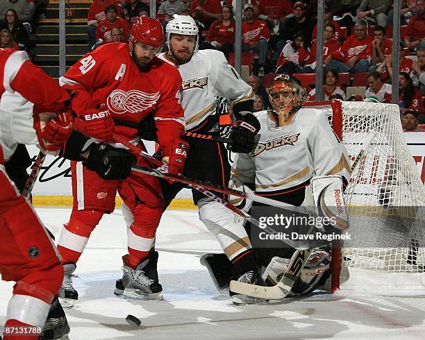 Henrik Zetterberg of the Detroit Red Wings battles for position in front of the net with Petteri Nokelainen of the Anaheim Ducks as goaltender Jonas...
