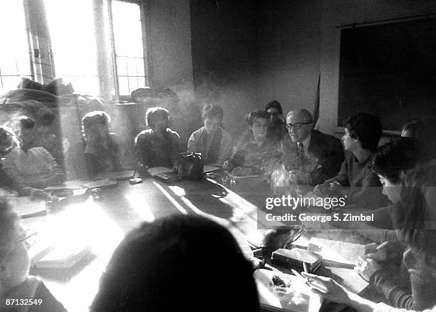 Group of students gathered around a table discussing lessons during a seminar at Sarah Lawrence College, Bronxville, NY, 1960s.