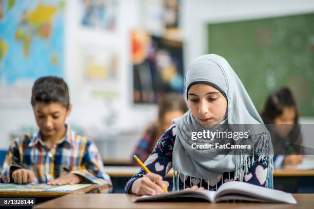 schrijven in een notitieblok - muslim boy stockfoto's en -beelden