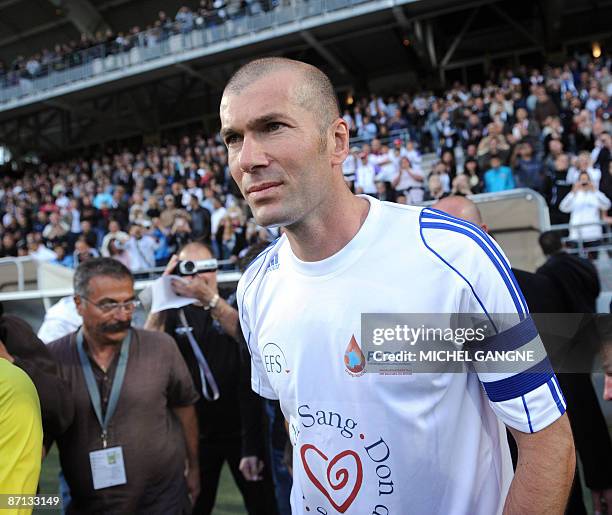 French former football player Zinedine Zidane arrives on the pitch to participate in a charity football match opposing Istres and Zidane's family and...