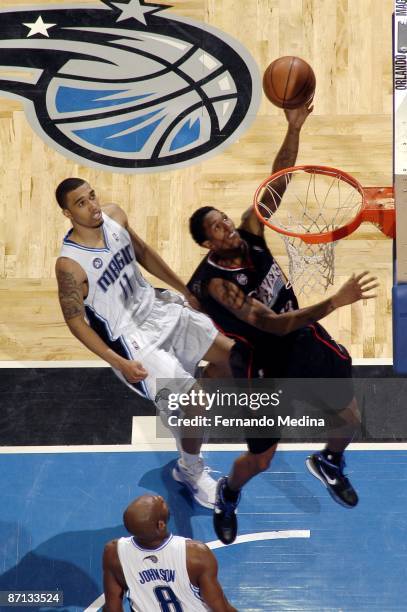 Louis Williams of the Philadelphia 76ers shoots a layup against Courtney Lee and Anthony Johnson of the Orlando Magic in Game Two of the Eastern...