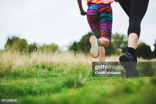 sporty women running together - running spikes stock pictures, royalty-free photos & images