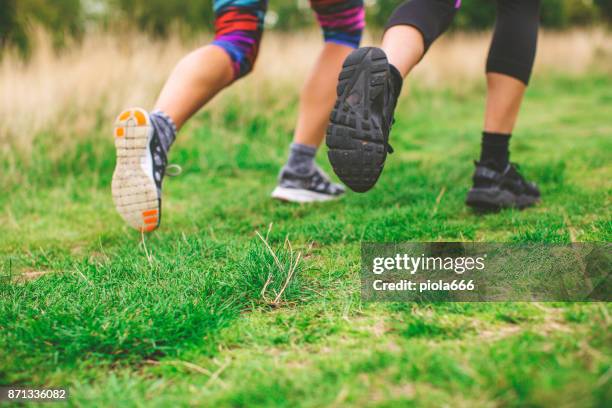 sporty women running together - running spikes stock pictures, royalty-free photos & images