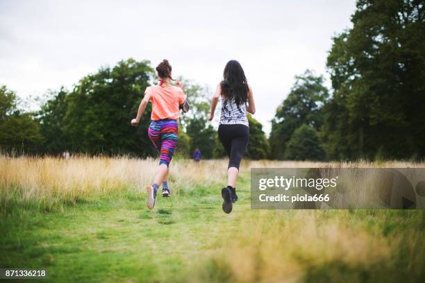 sporty women running together - running spikes stock pictures, royalty-free photos & images